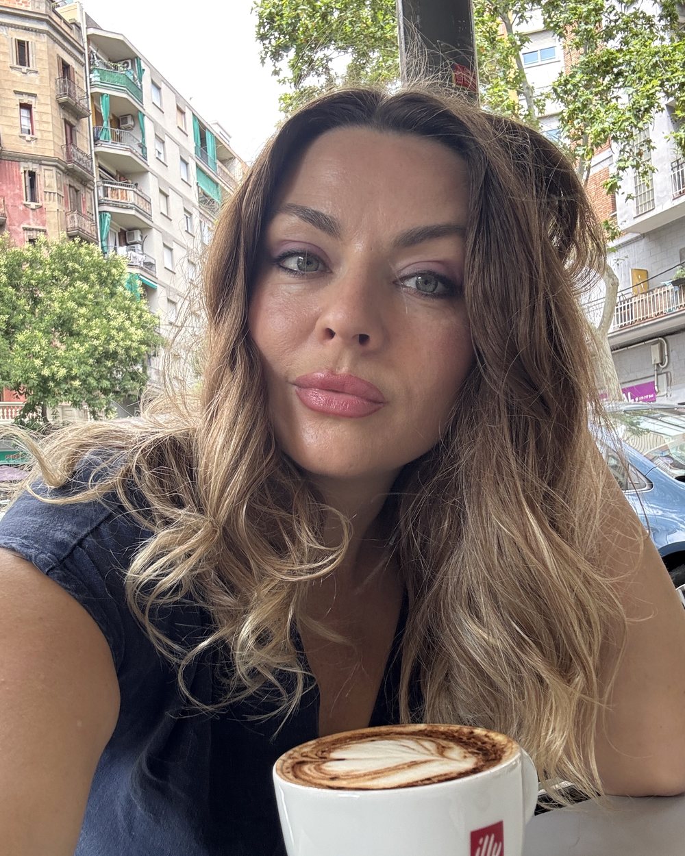 Delfina writing at her laptop with coffee