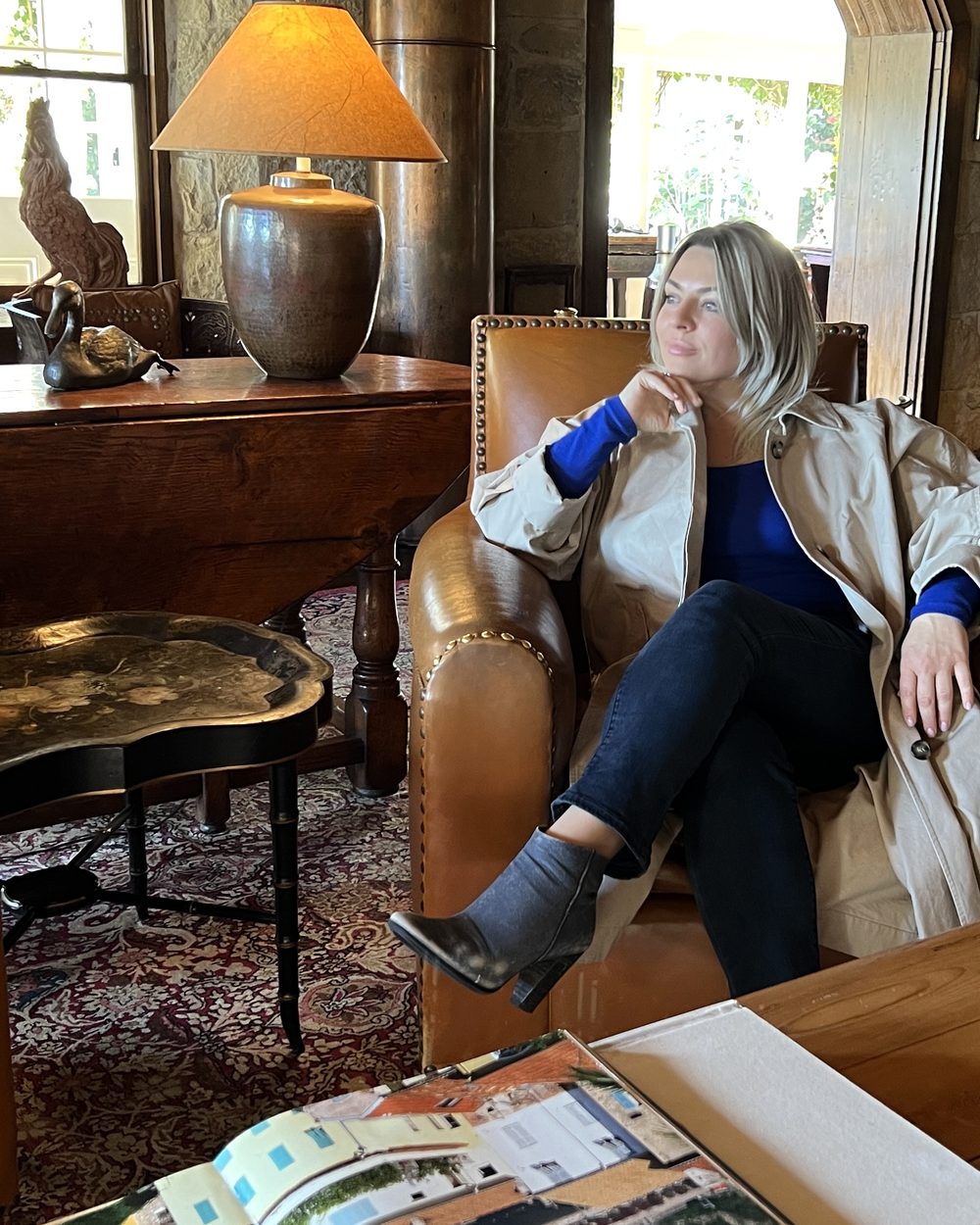 Delfina Alden in a leather armchair, thinking
